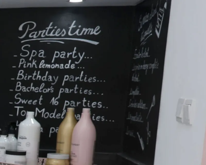 Le tableau noir du Hair Lab écrit à la craie : « Parties time — Spa party, Pink lemonade, Birthday parties, Bachelor’s parties, Sweet 16 parties, Top Model parties »